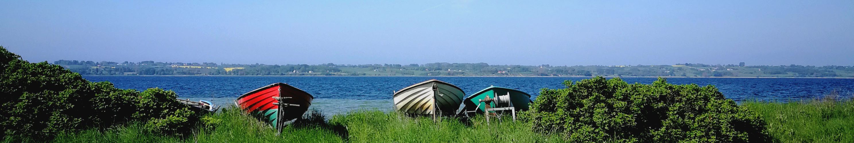 Grüne Wiesen mit Meer und Booten